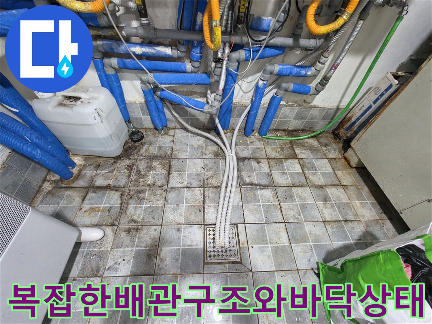 송파구 고시원 현장의 복잡하게 얽힌 파란색 배관과 물기 어린 타일 바닥 모습