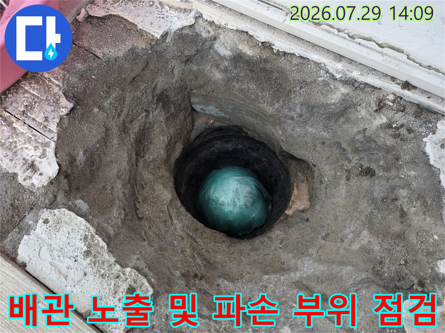 파헤친 시멘트 아래 드러난 배수관과 연결부