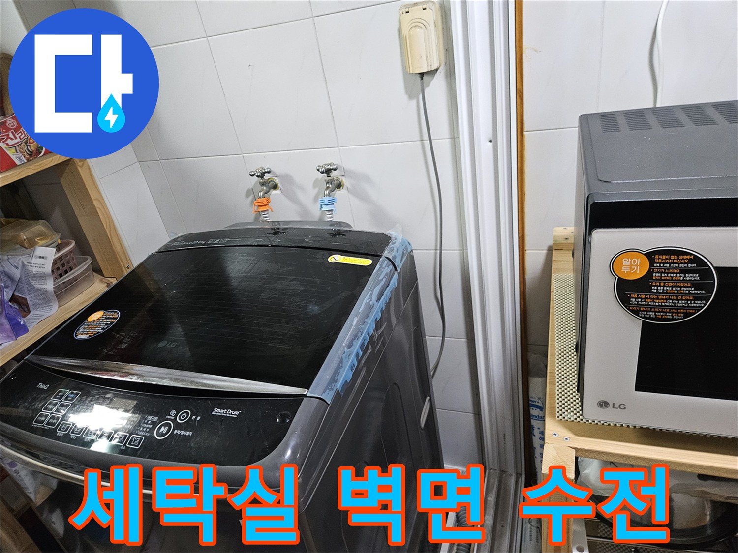 세탁기가 놓인 공간의 수도꼭지와 타일 벽면 사진
