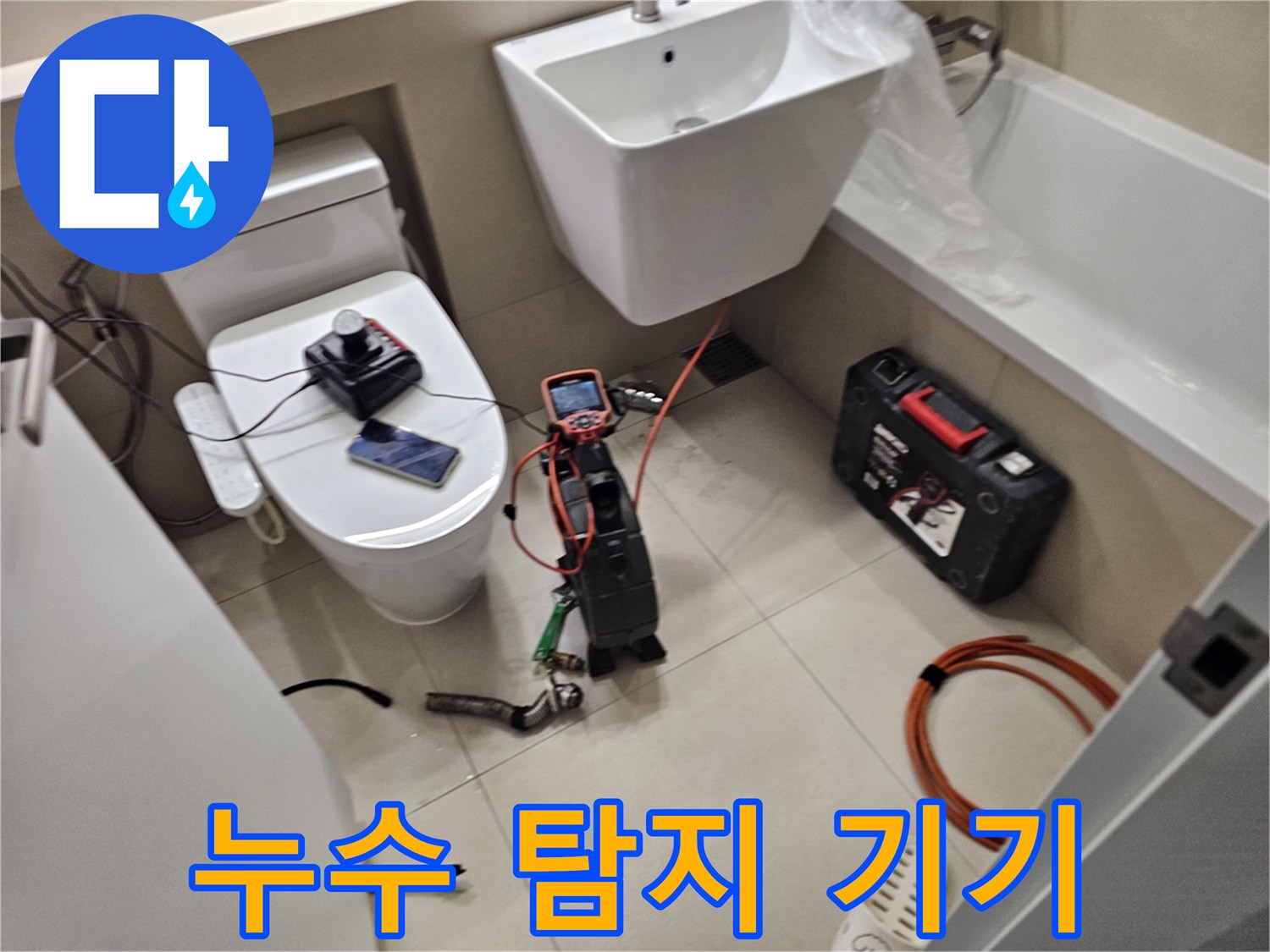 세면대 및 변기 아래 놓인 누수 측정 장비와 배터리 세트