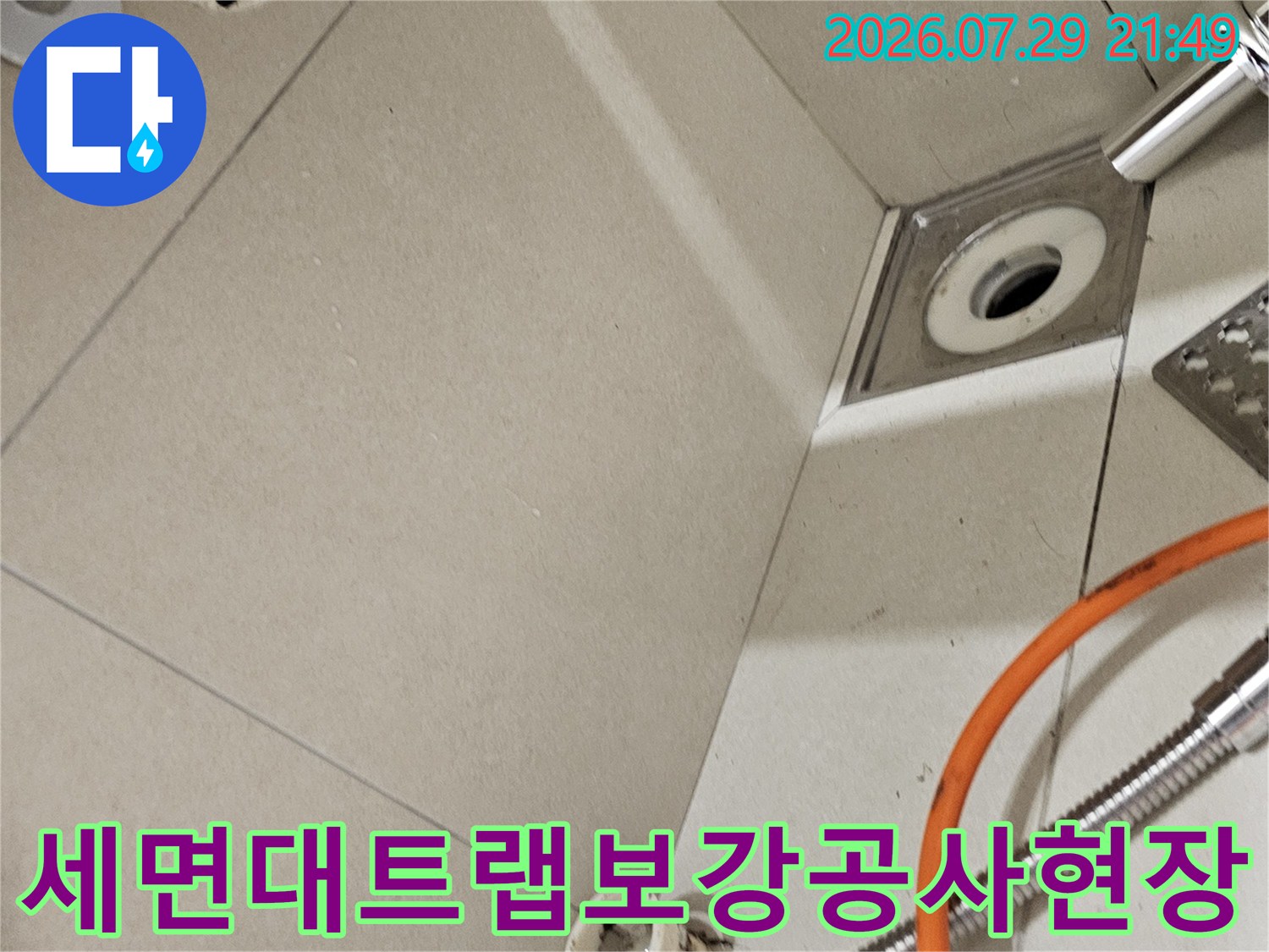 세면대 하부의 트랩과 배출구를 신규 부속으로 교체하고 마감하는 장면