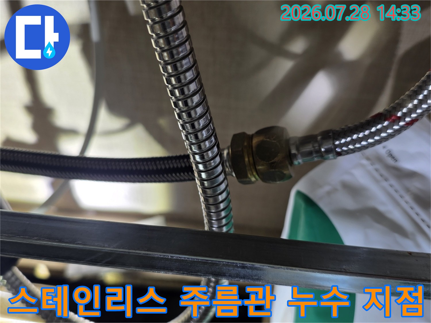 금속 재질의 배관 연결 너트 주변에 물기가 맺혀 있는 근접 사진