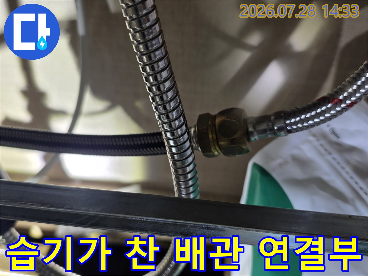 스테인리스 주름관의 너트 체결 부위에서 누수가 발생해 젖어있는 모습