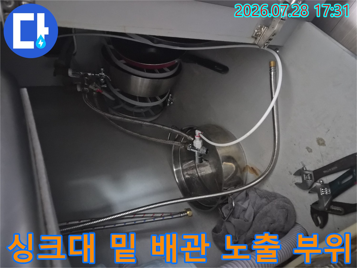 식기세척기 연결용 스테인리스 호스와 밸브가 위치한 싱크대 하단부입니다.
