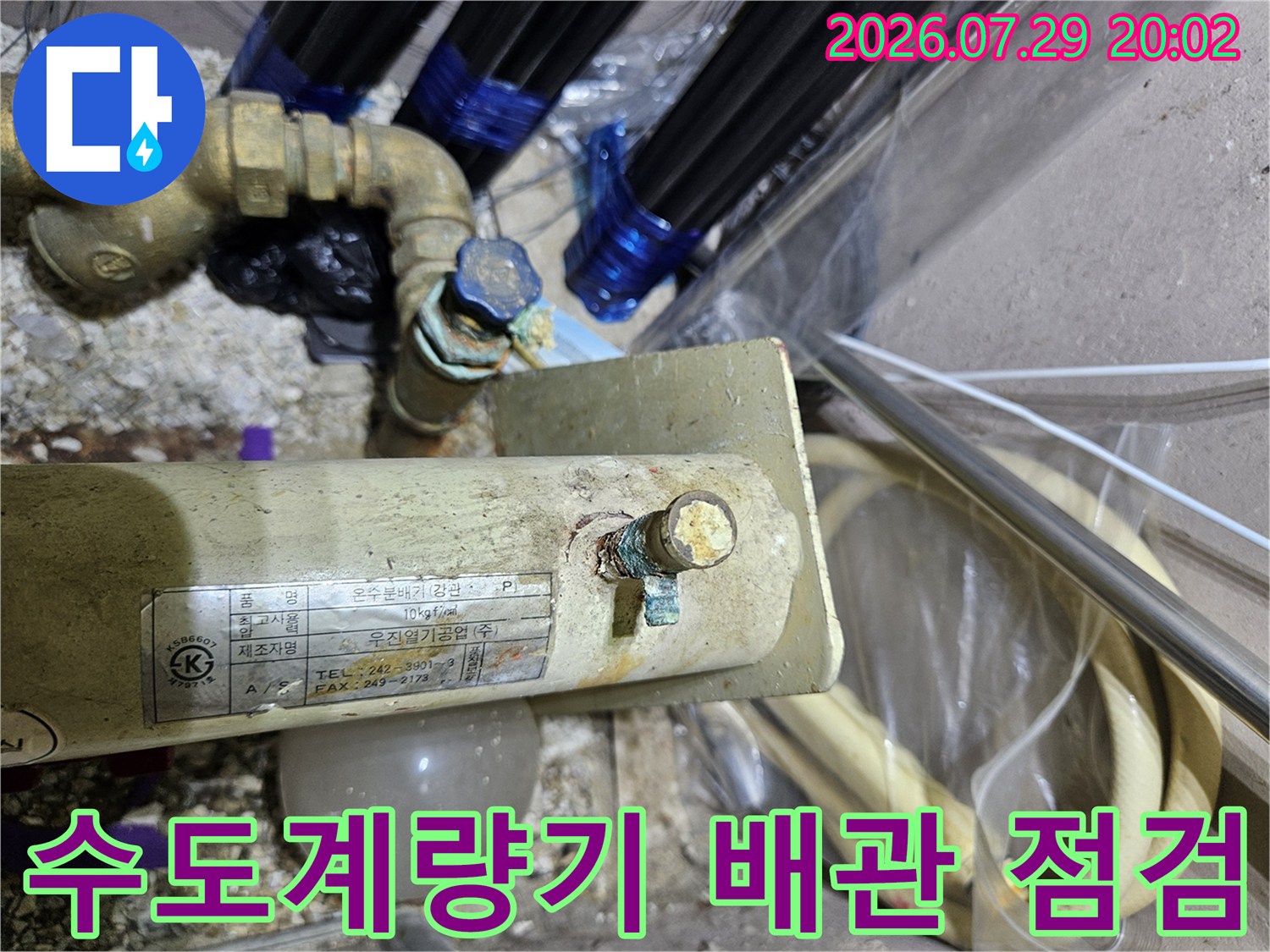 노란색 수도계량기와 연결된 금속 배관의 정밀 점검 모습
