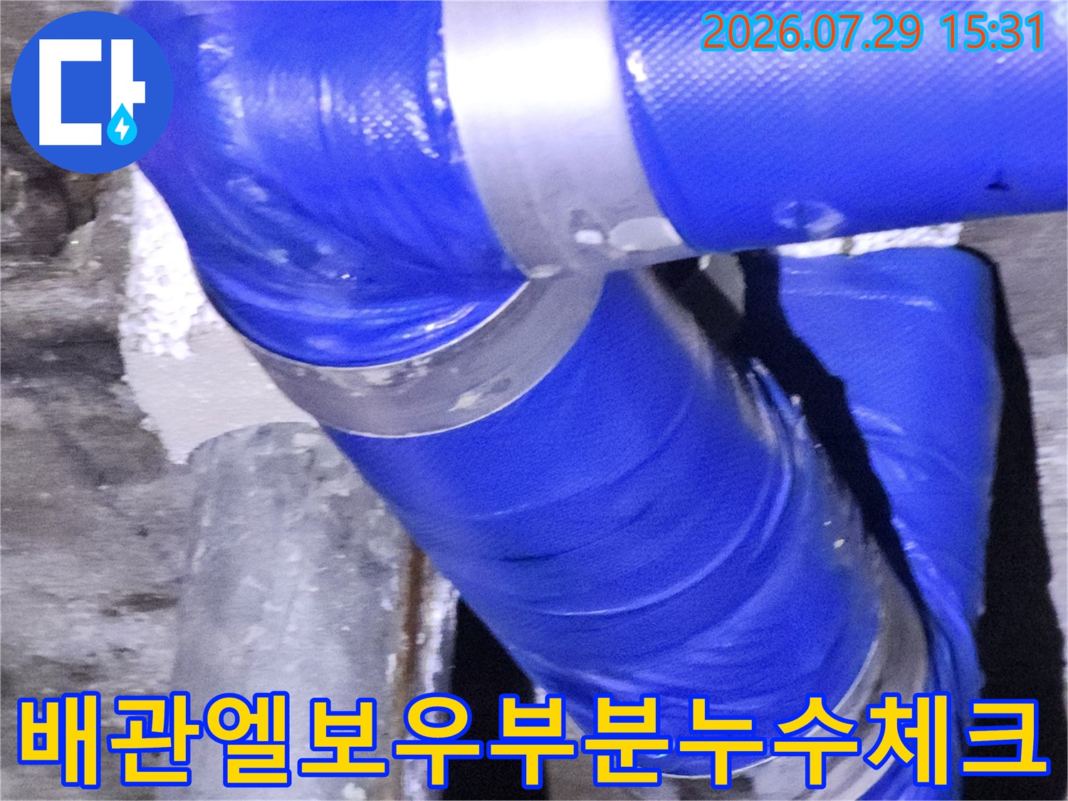 파란색 배관 굴곡 부위의 누수 여부를 점검하는 장면
