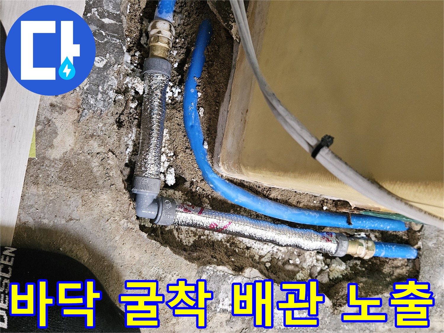 콘크리트 아래 드러난 파란색 수도 배관의 연결 부위 정비 모습