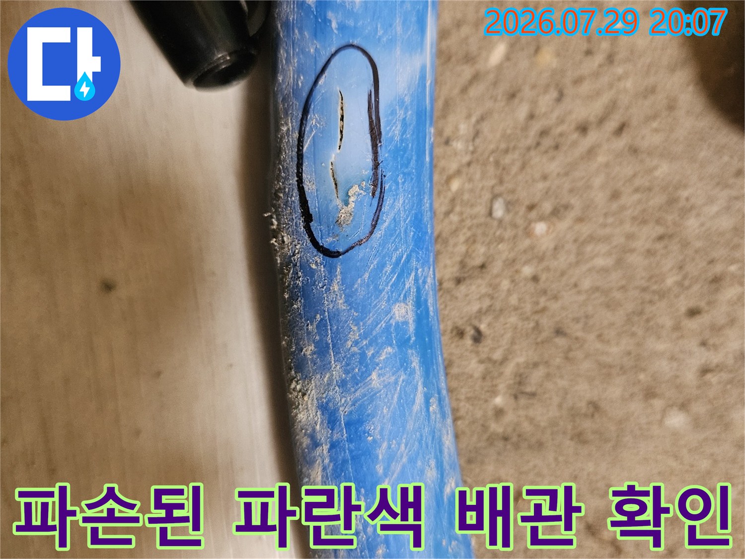 파손 부위가 표시된 파란색 온수 배관 사진