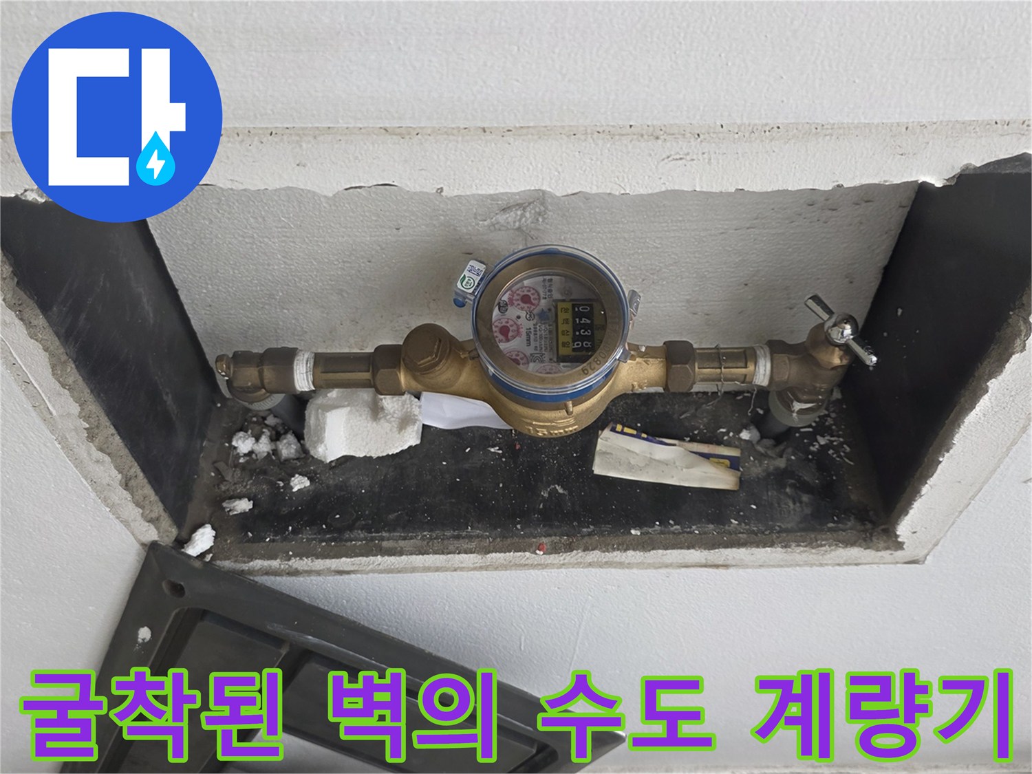 벽면을 파내어 드러낸 황동 소재의 수도 계량기와 밸브