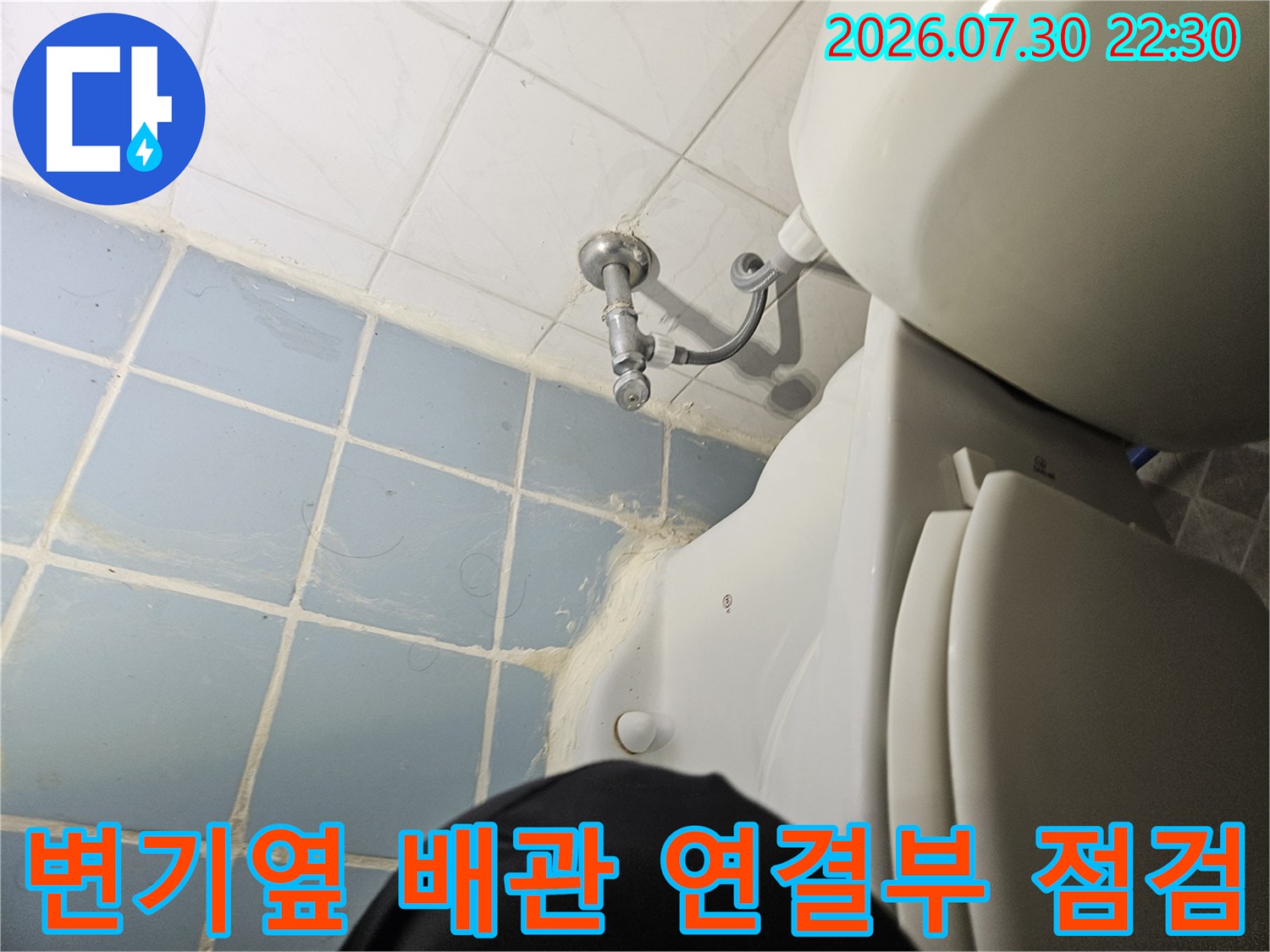변기 옆면 노출된 하수 배관과 타일 벽면의 결합 부위 촬영 사진