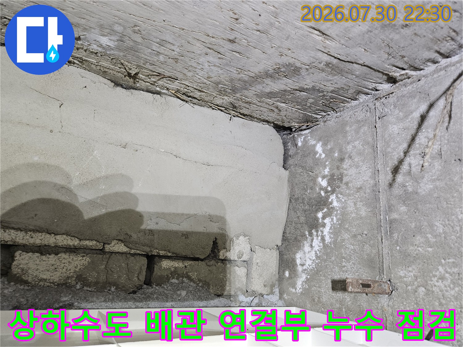 콘크리트 천장에서 노출된 하수 배관의 습기 및 변색 부위
