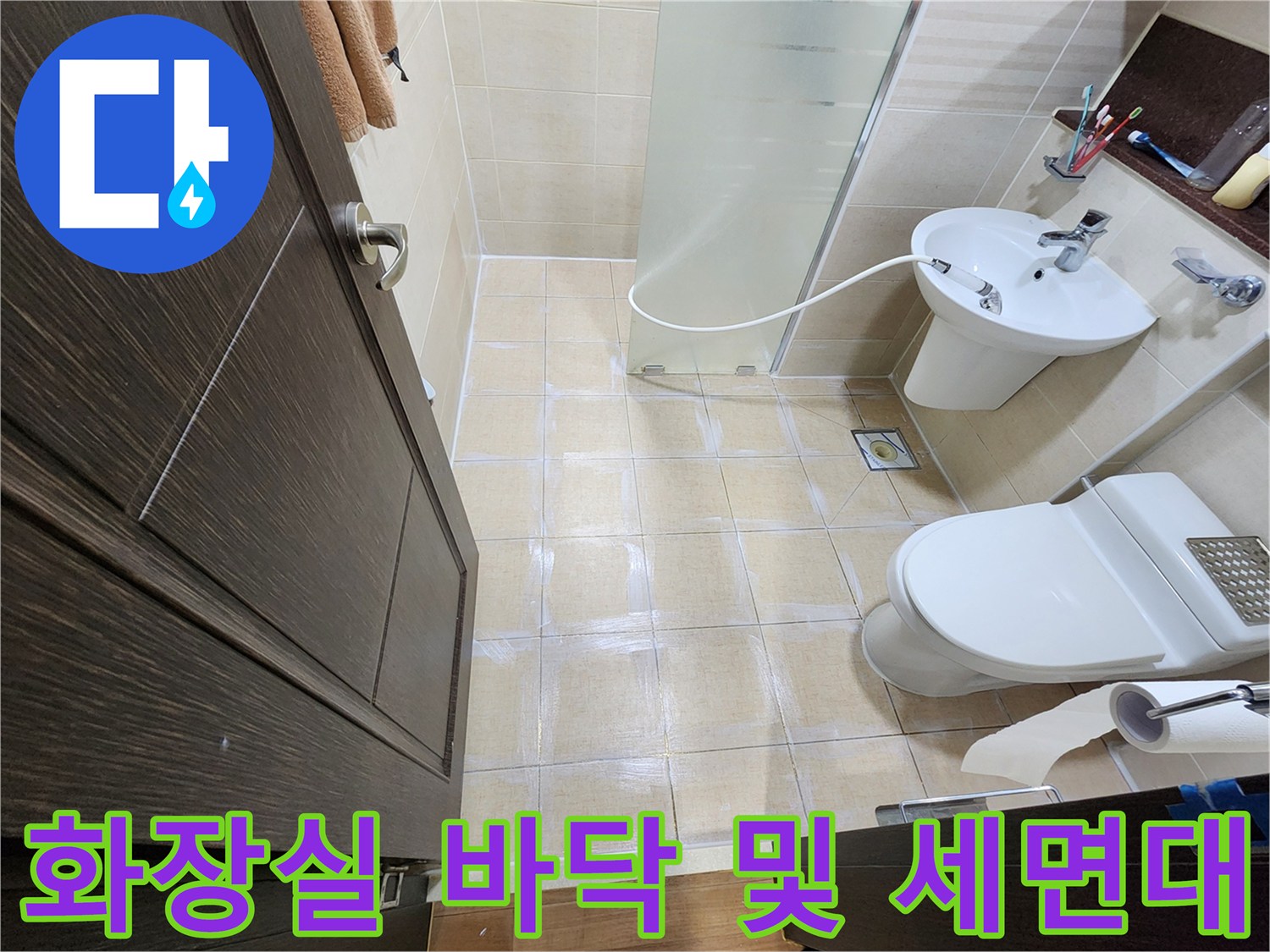 세면대와 변기가 설치된 욕실의 타일 마감 상태 촬영