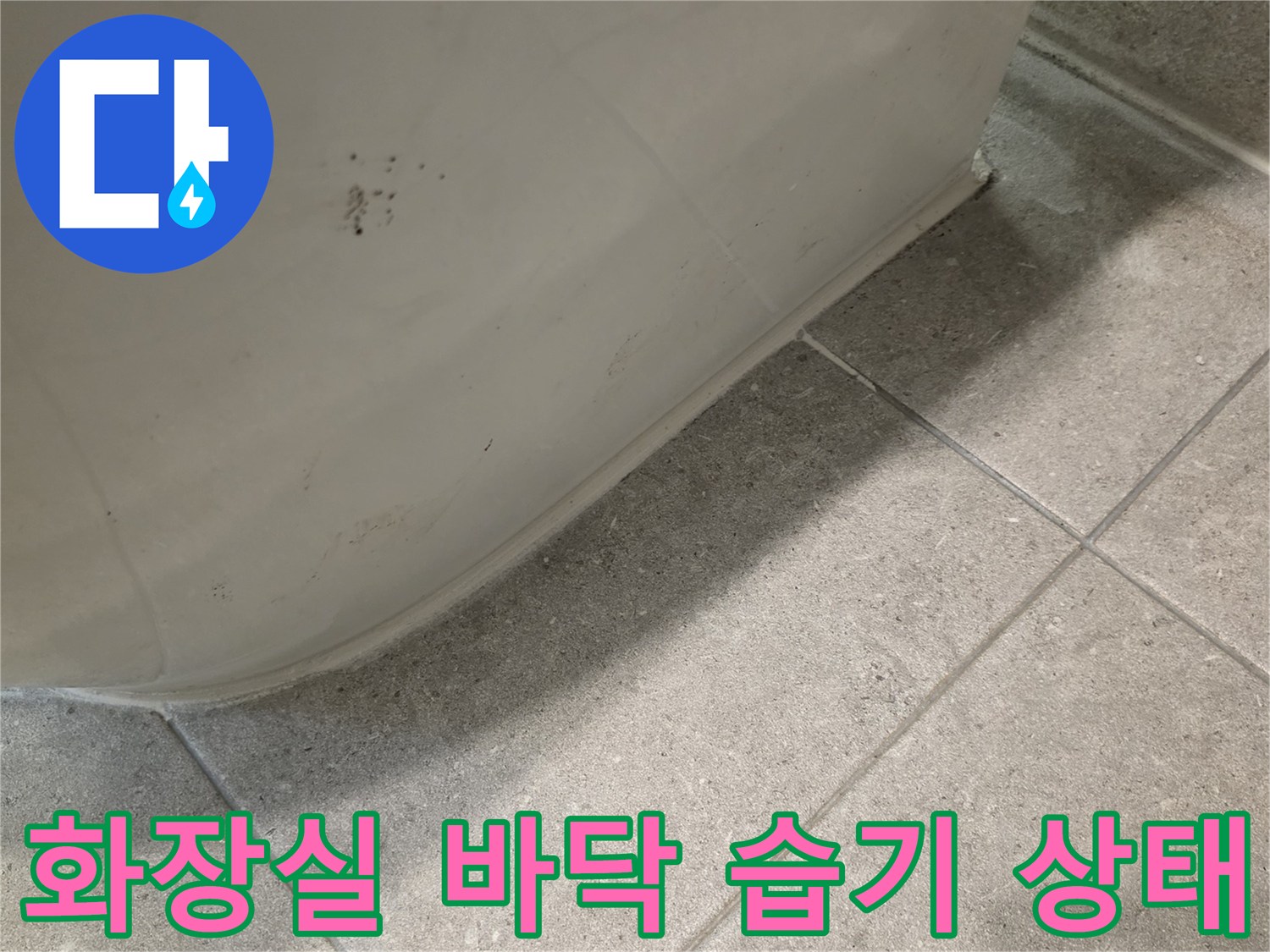 변기 하단-타일 틈새로 스며든 습기와 오염된 상태를 보여주는 사진입니다.