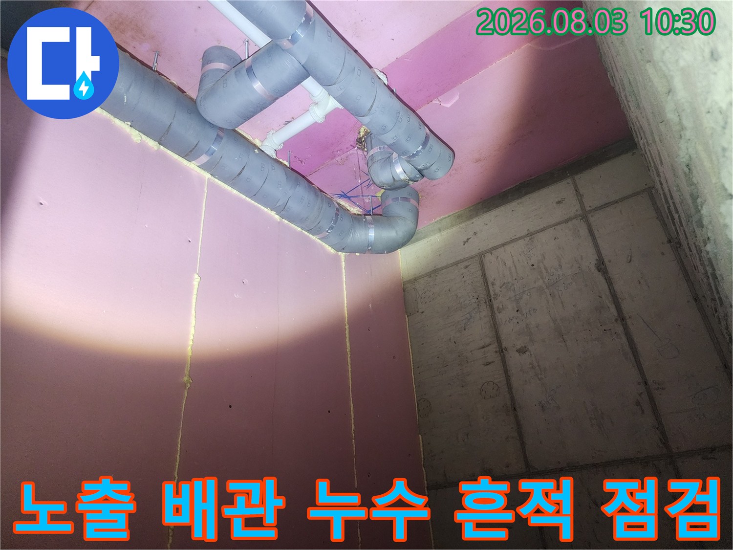 분홍색 벽체와 연결된 복잡한 배관 시스템의 상세 촬영 사진