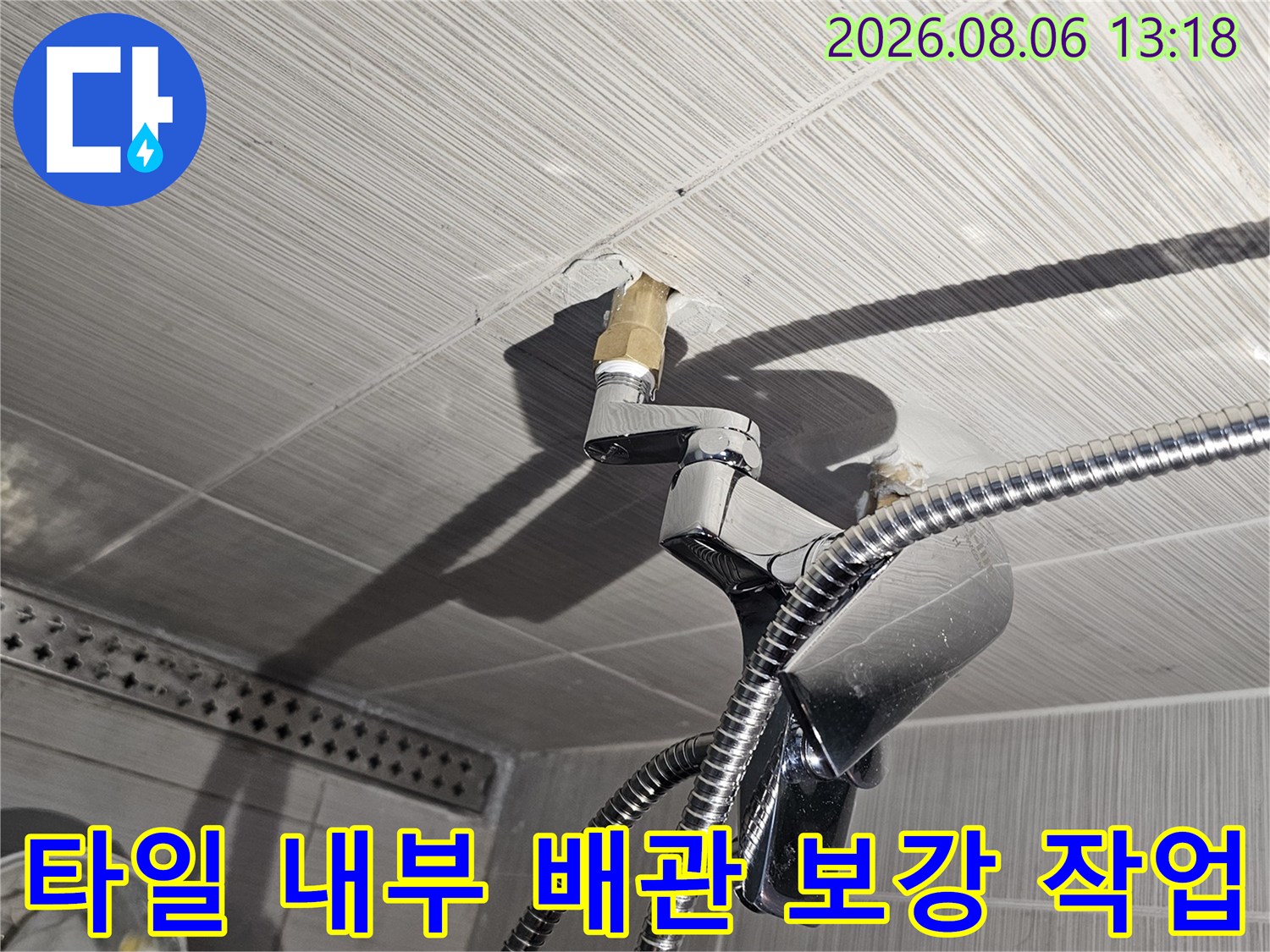벽면 타일 안쪽의 샤워기 수전 연결 부위를 새로운 소켓으로 교체한 장면