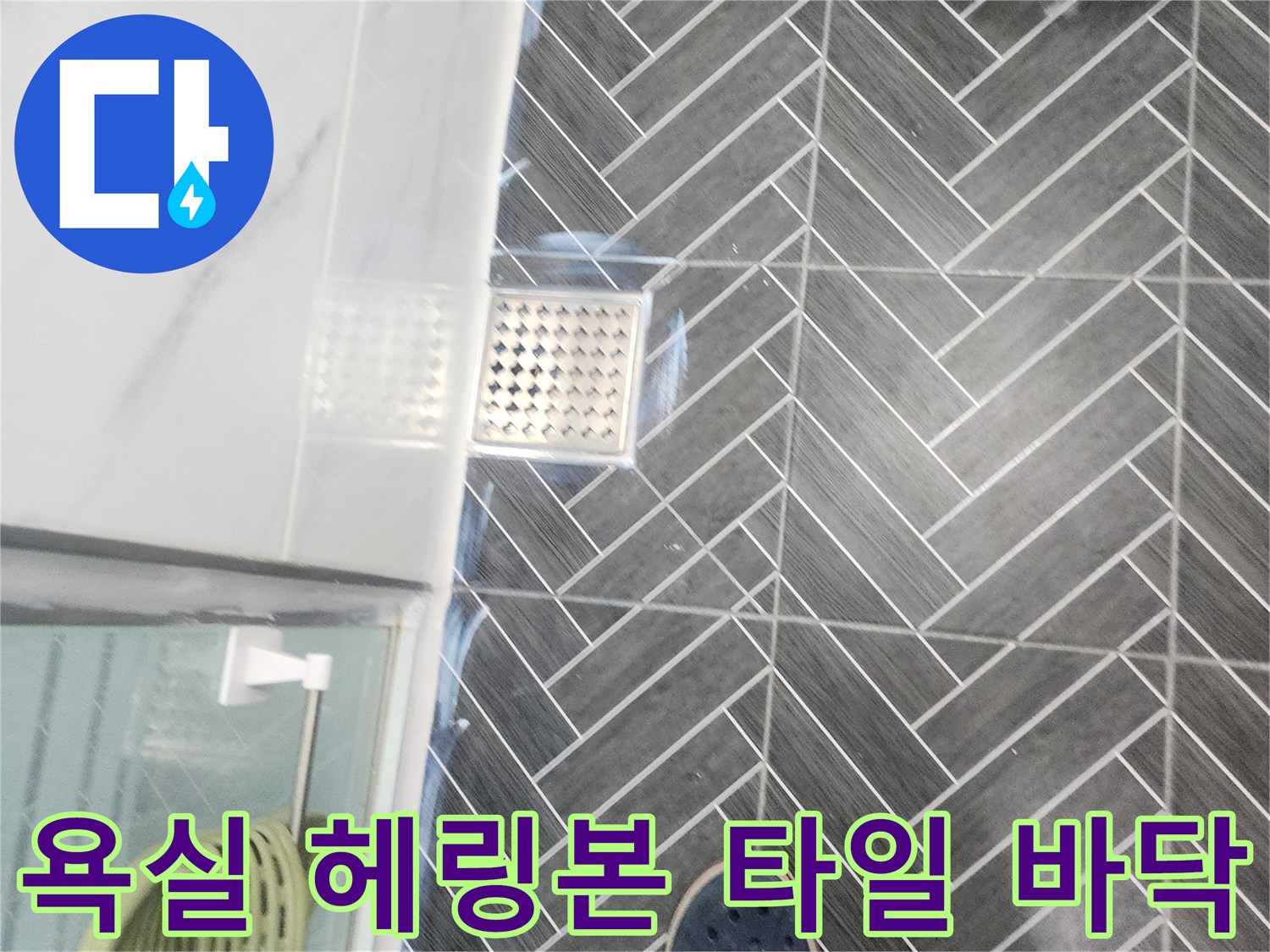 배수구와 인접한 헤링본 패턴의 욕실 바닥 타일 상세 이미지