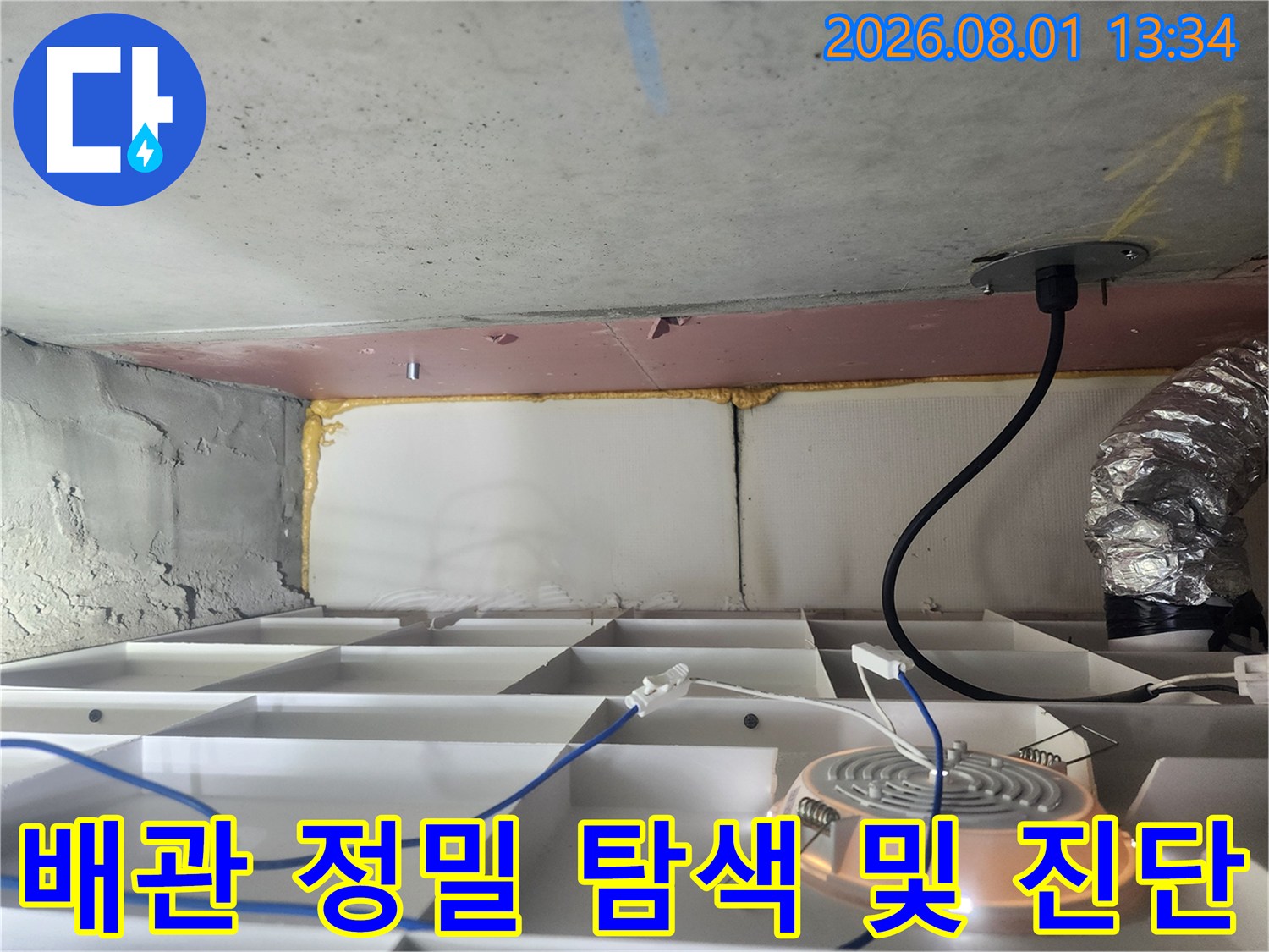 천장 내부에 노출된 배관 시스템에 장비를 연결하여 누수 여부를 확인하는 모습