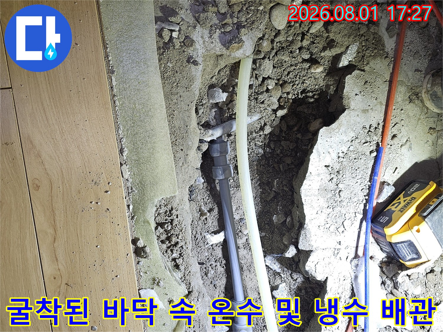 바닥 파쇄 후 노출된 온수와 냉수 배관을 점검하고 보수하는 공사 현장