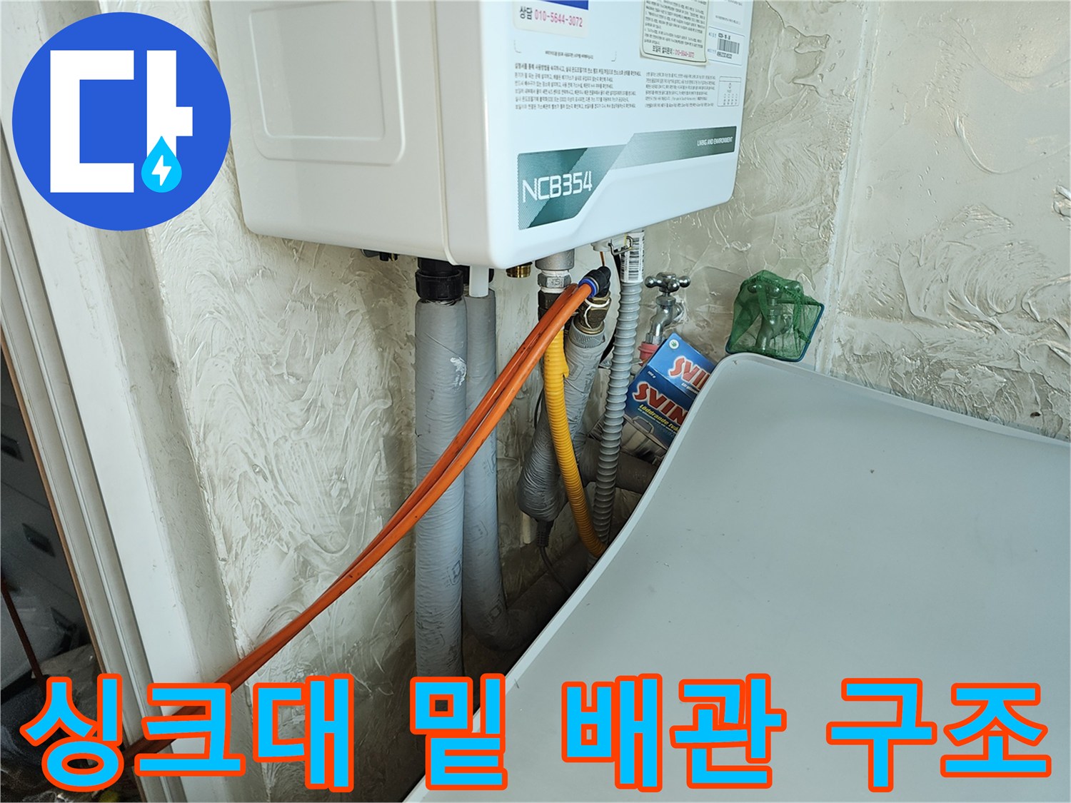 보일러 하부의 주황색 호스와 회색 배관이 연결된 모습 - 누수 원인 파악 중