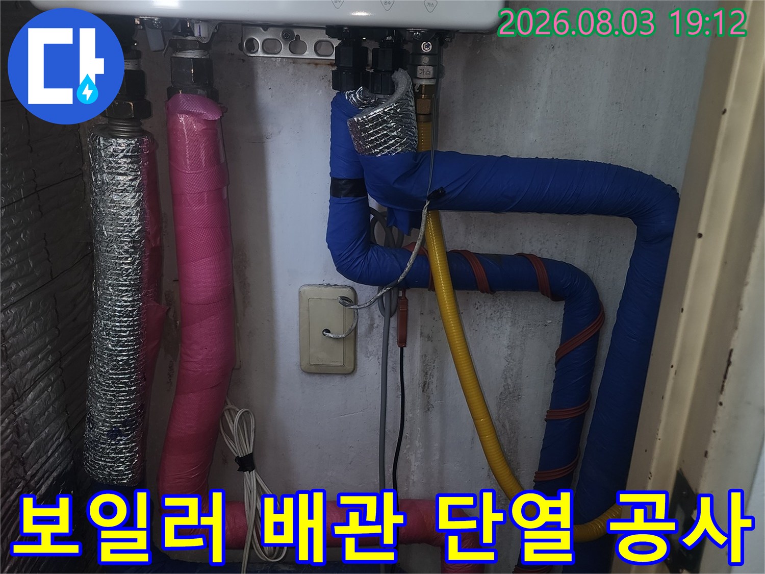 노출된 보일러 배관에 분홍색과 파란색 단열재를 감싸고 보강한 모습