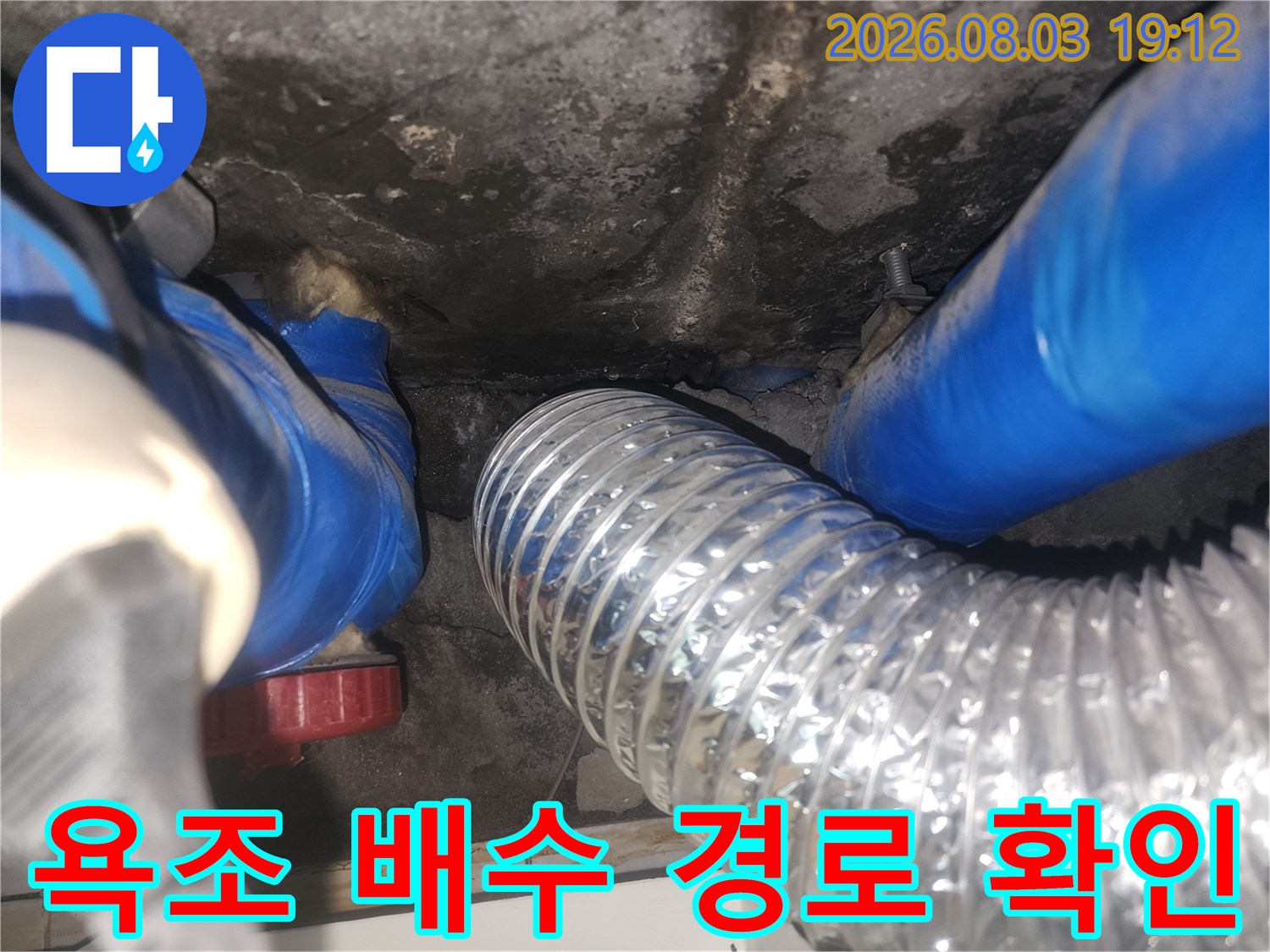 은색 주름 호스와 파란색 보호재가 결합된 배수 시스템 점검