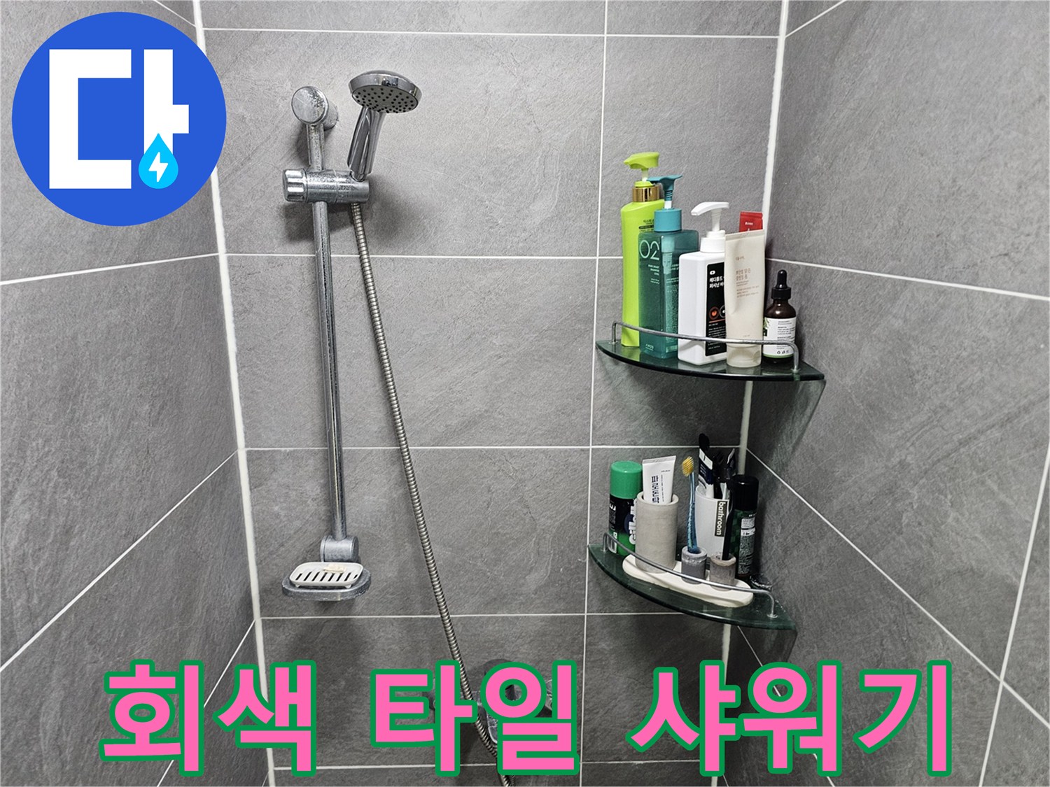 그레이 톤의 욕실 타일과 수전 장치 이미지