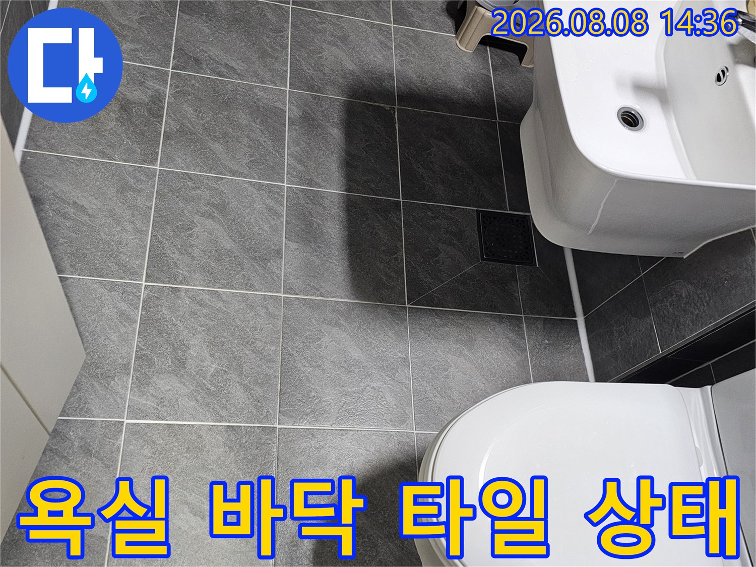 변기와 세면대가 설치된 욕실 내부의 타일 시공 모습입니다.