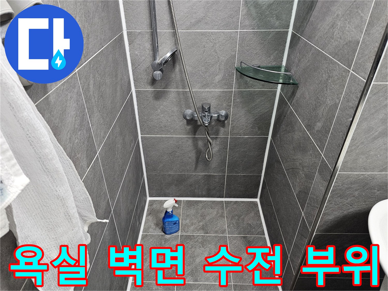 샤워기 수전과 세정제가 놓인 욕실 벽면