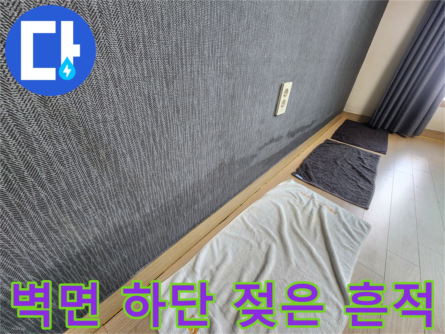 벽면 하단부의 도배지가 젖어 얼룩진 모습입니다.