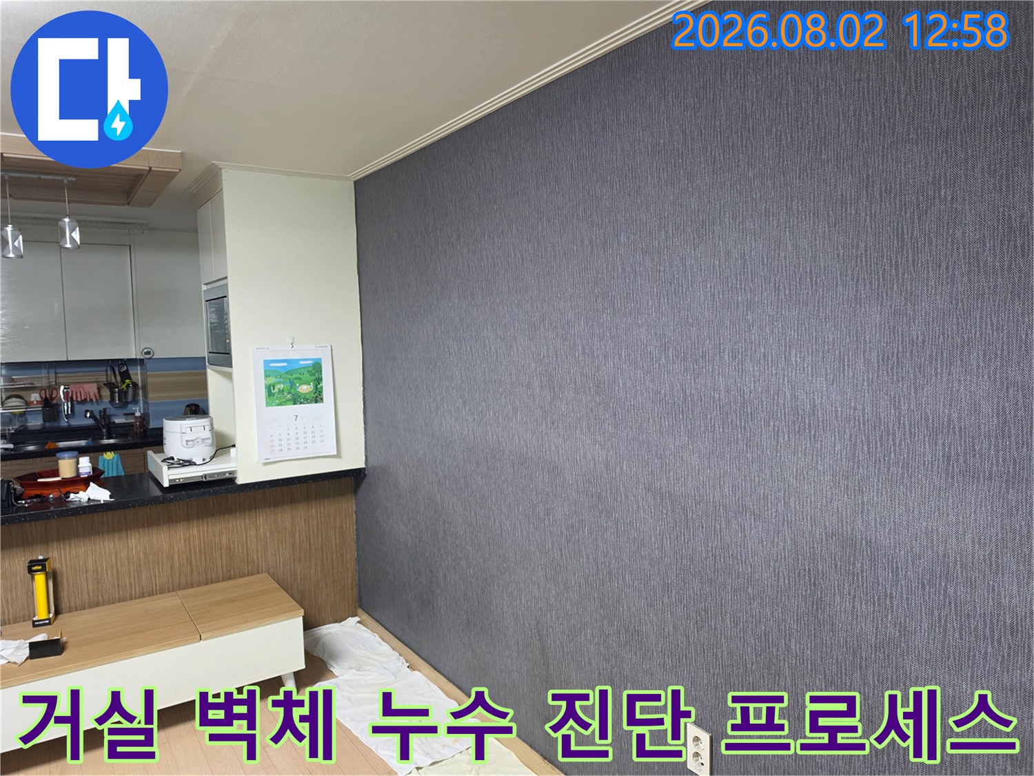 어두운색 거실벽면과 가구 옆에서 진행되는 체계적인 누수 조사