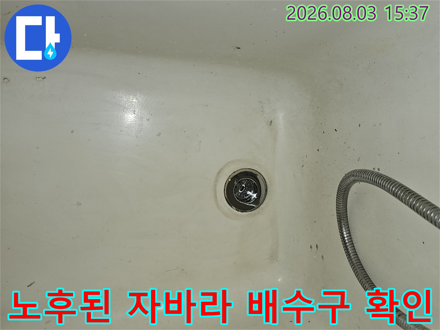 금속 재질의 욕조 배수 트랩과 은색 주름 호스