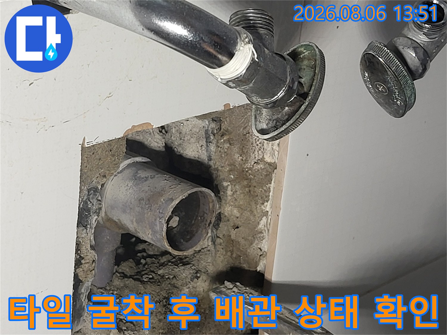 누수 지점을 파악하기 위해 타일을 제거하고 노출시킨 수도 배관 모습