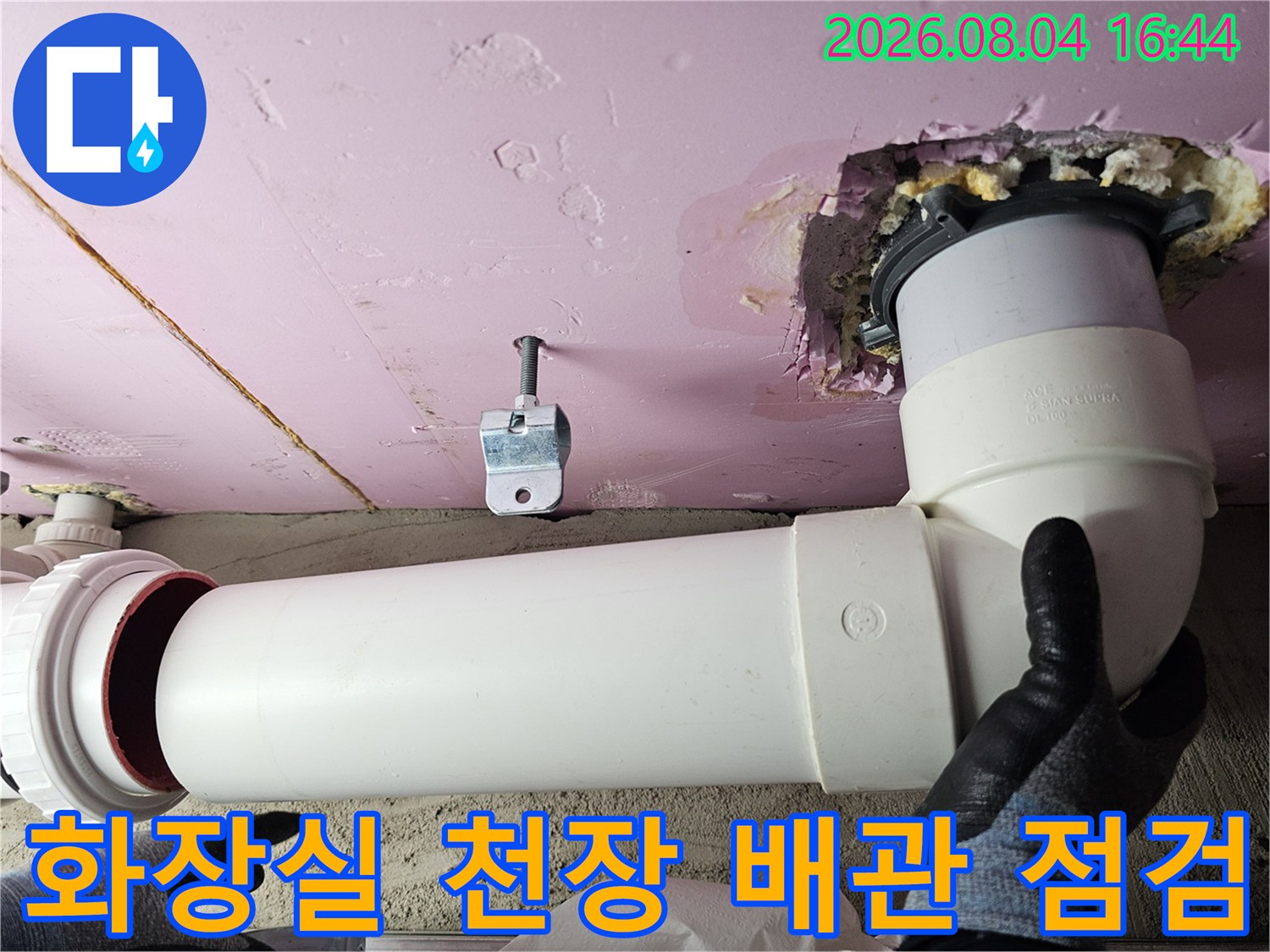 아파트 화장실 천장 내부의 하얀색 배관 연결 부위 점검 모습