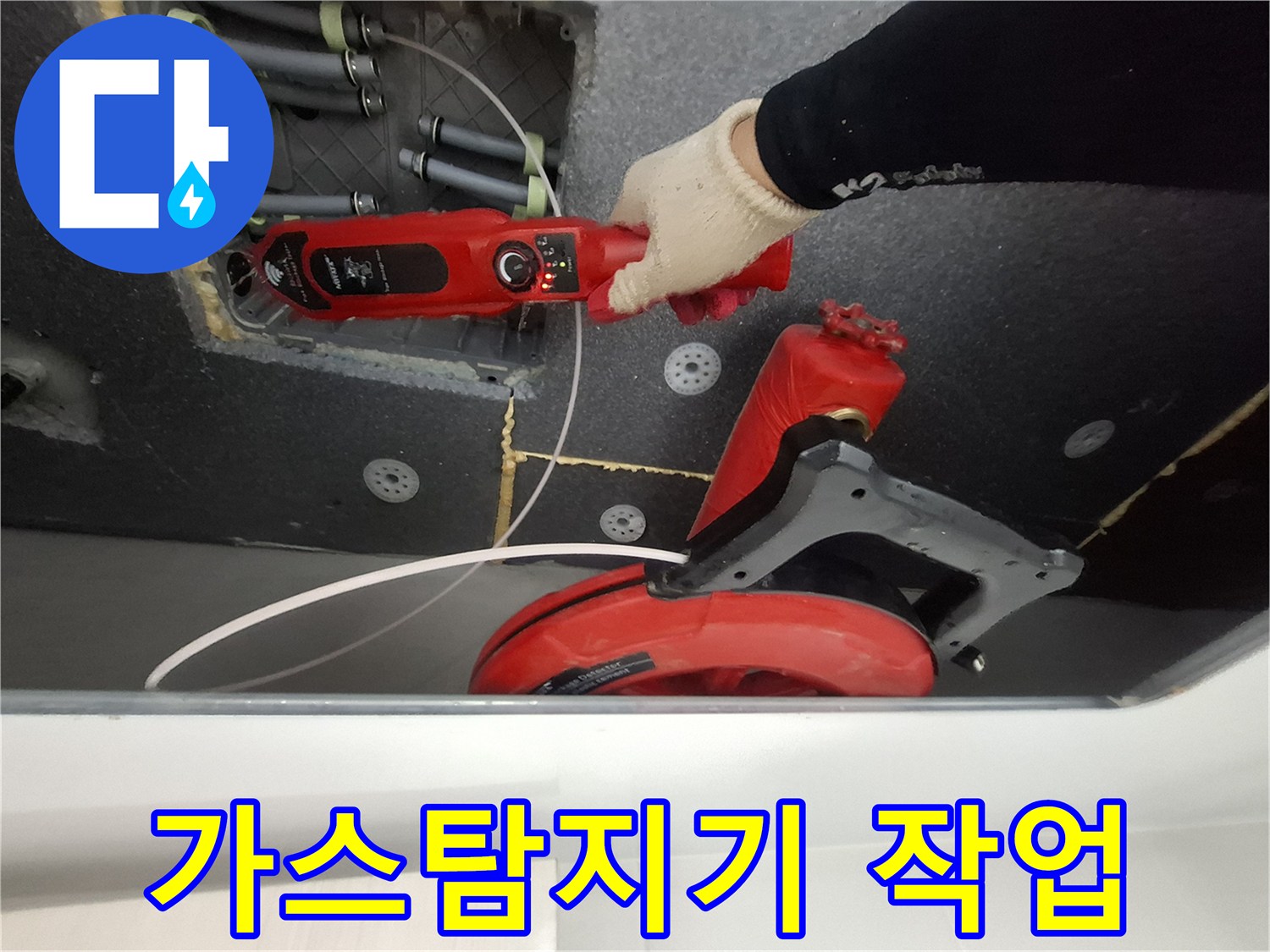 화장실 천장 배관 점검을 위해 가스 탐지기를 사용하는 모습