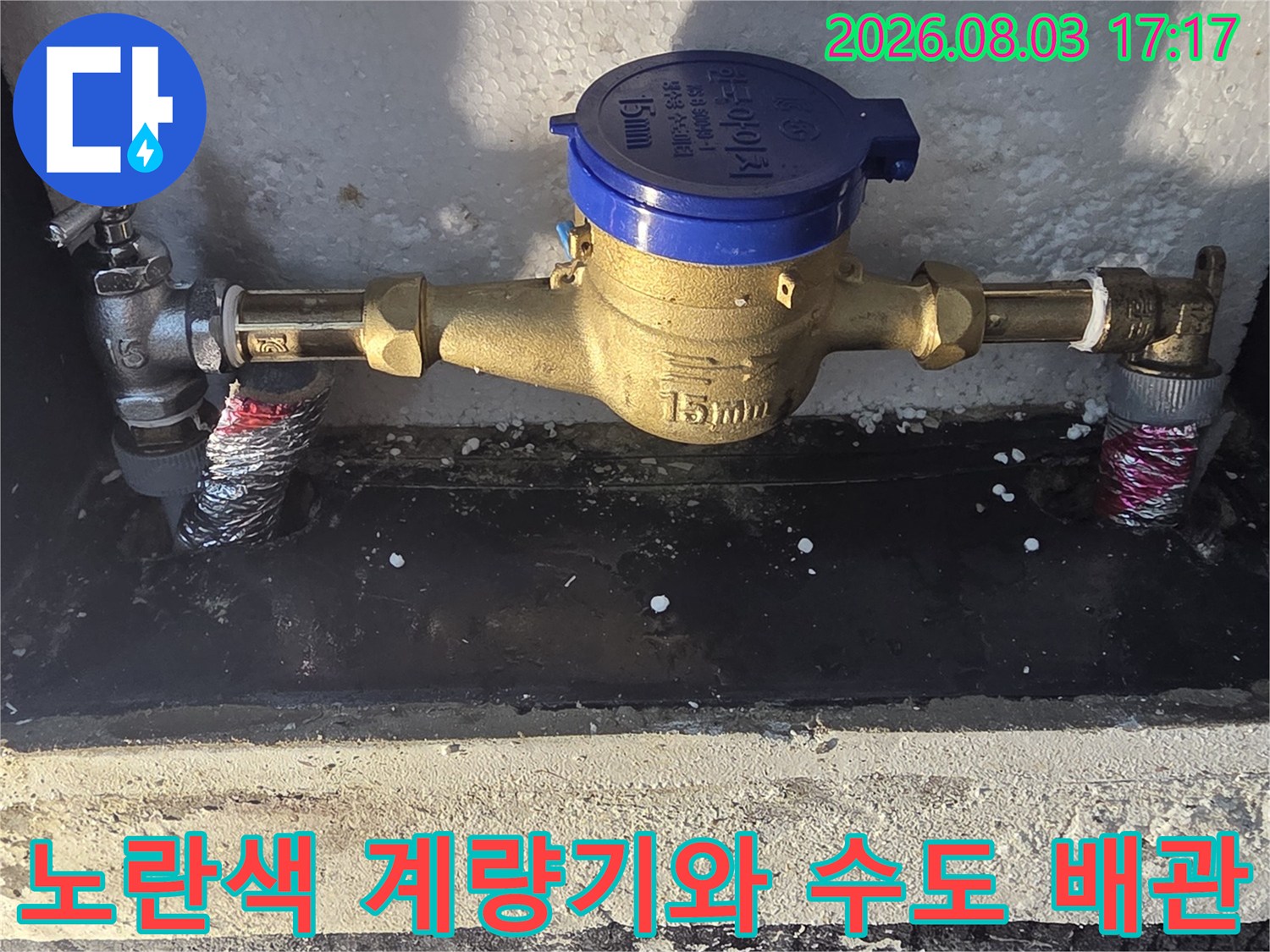금속 소재의 수도 배관과 노란색 계량기 부품