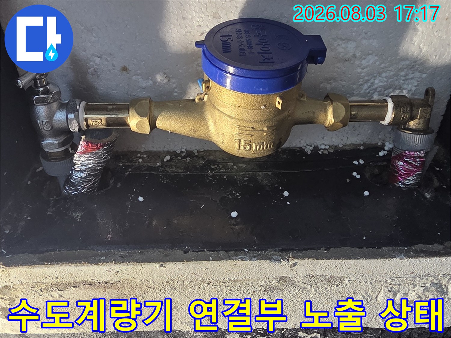 노출된 수도 배관과 파란색 계량기 수리 작업 현장
