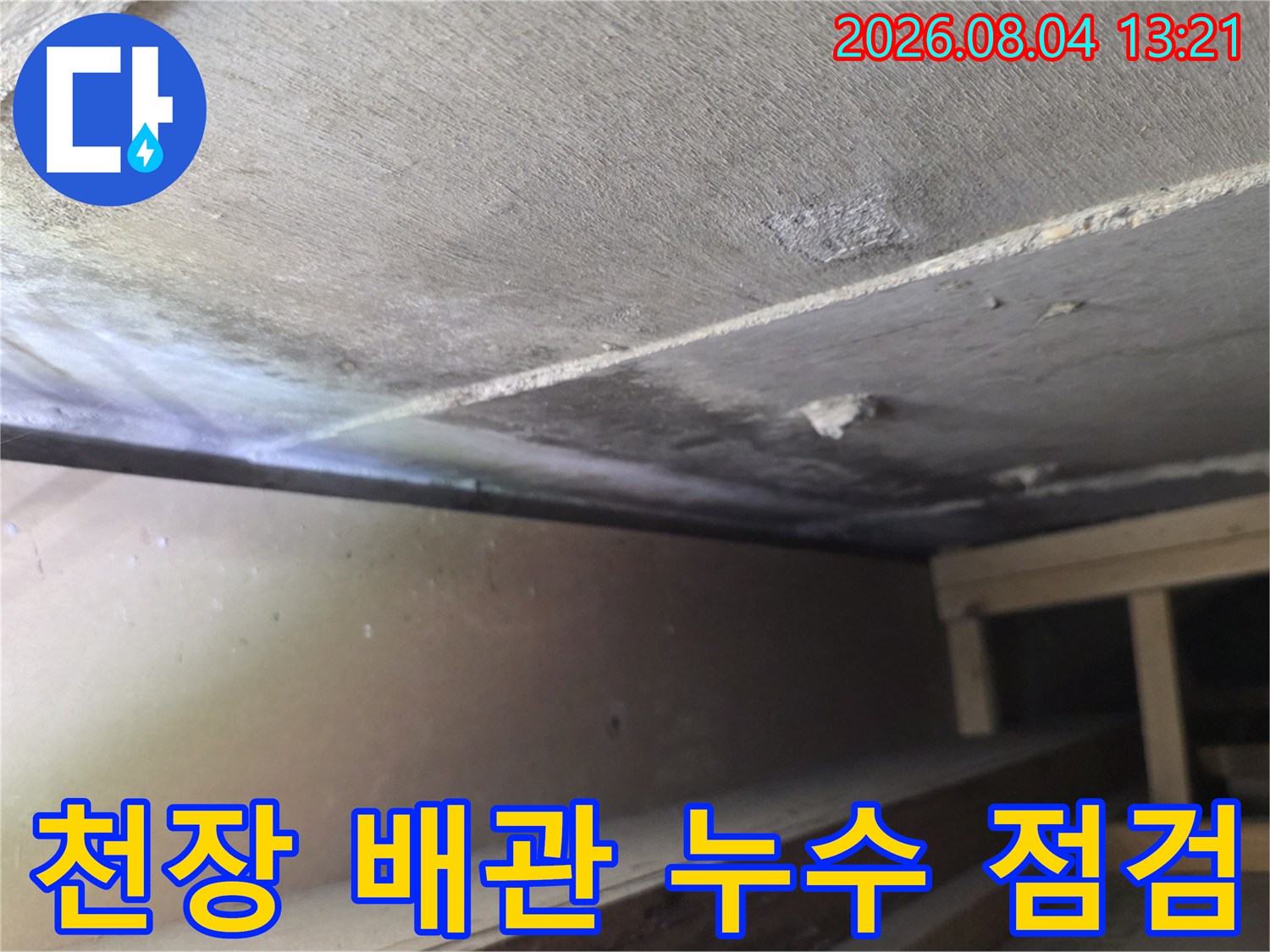 먼지가 쌓인 천장 안쪽 공간에서 노출된 배관을 살피는 현장 사진