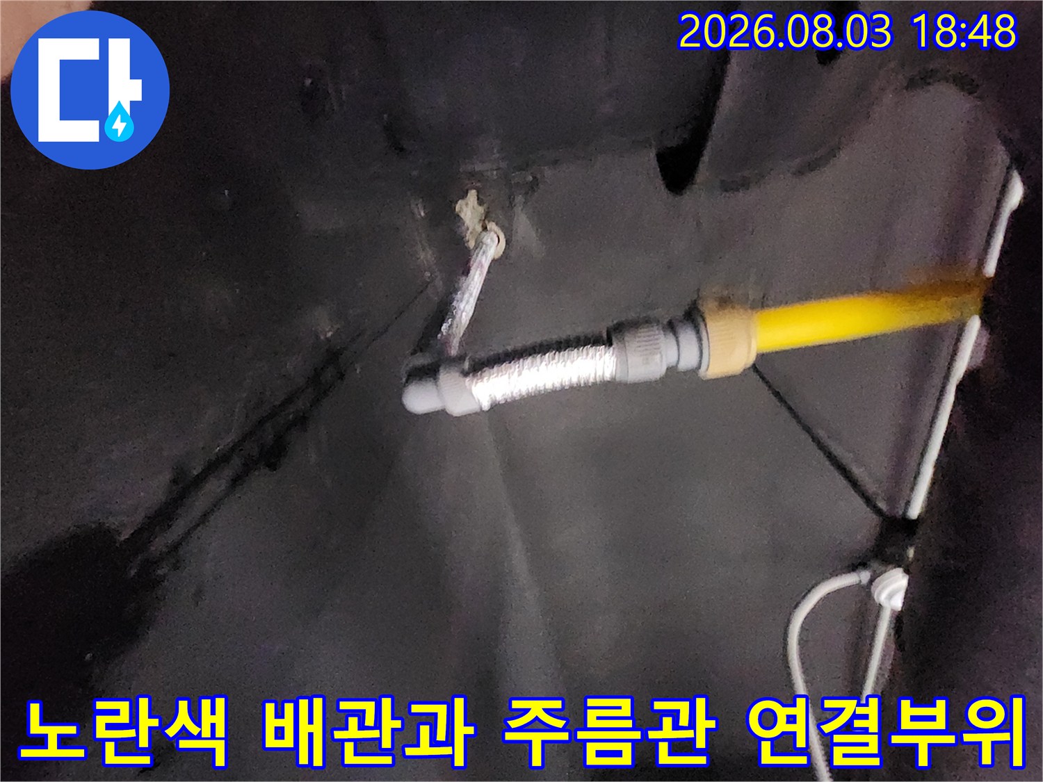 노란색 보호관과 금속성 주름 호스가 연결된 배관 부위
