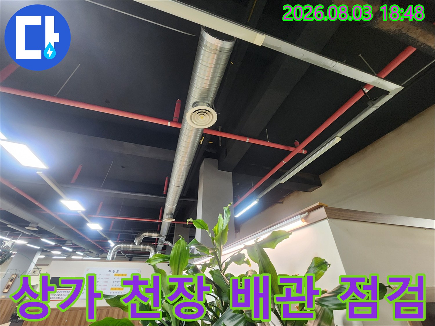 상가 건물 내부의 노출된 소방 및 급수 배관 시스템과 조명 시설