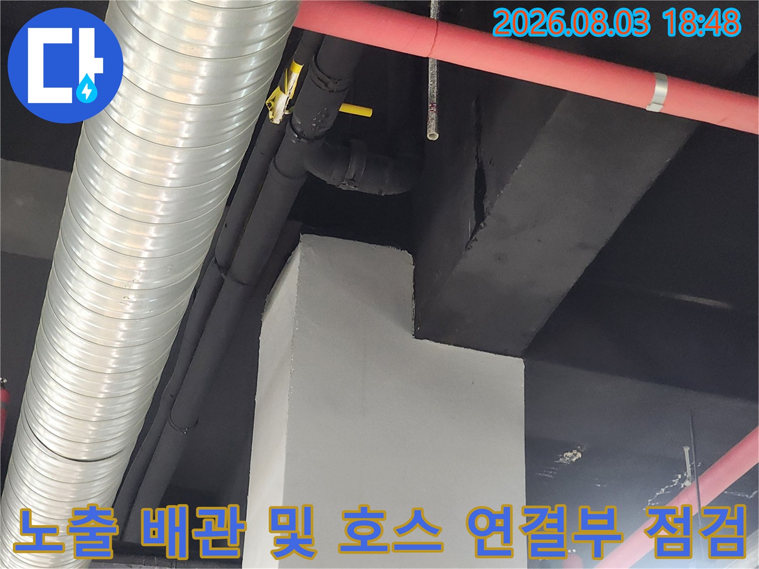 상가 천장과 벽면을 따라 설치된 노출 배관과 유연한 호스의 연결 상태를 점검하는 모습