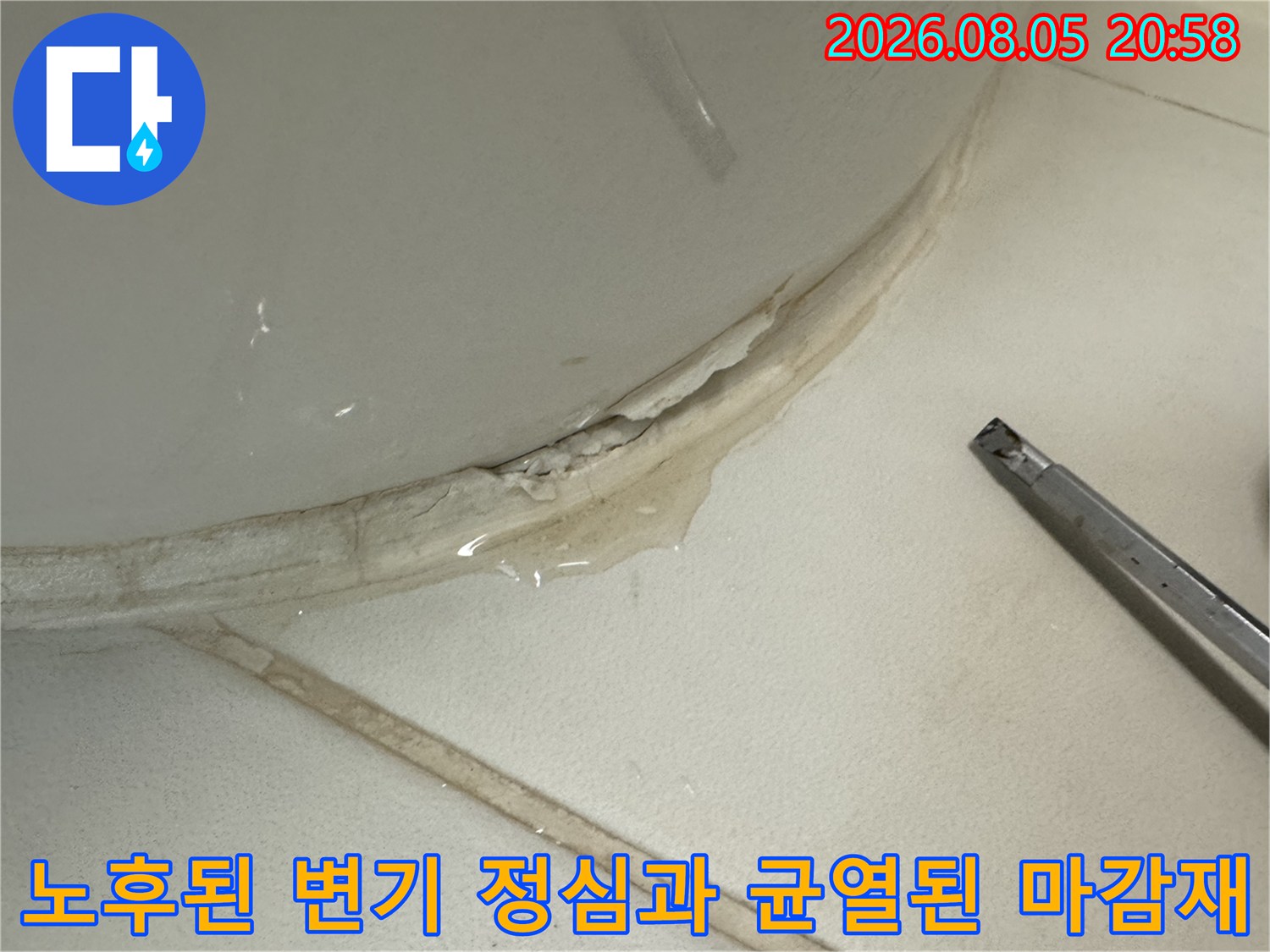변기 하단부의 파손된 백시멘트와 노출된 배관 연결 부위 사진