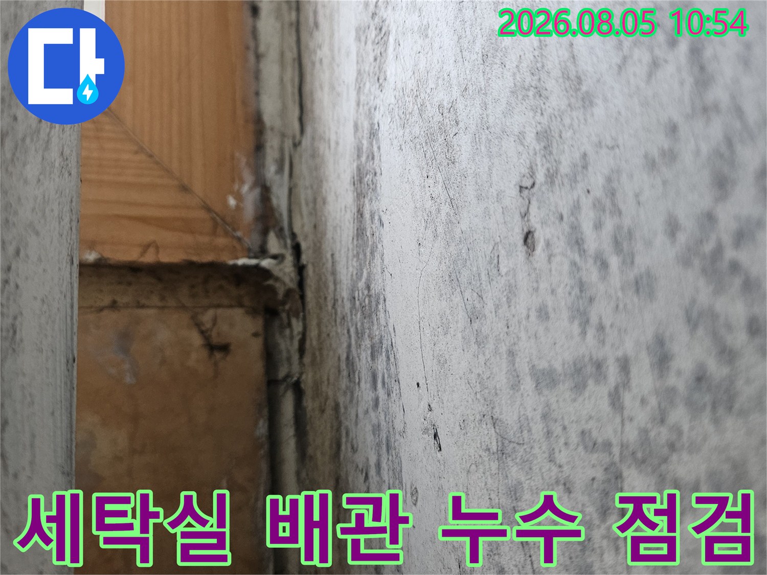 거친 질감의 시멘트 벽면과 노후된 배관 부위의 근접 촬영