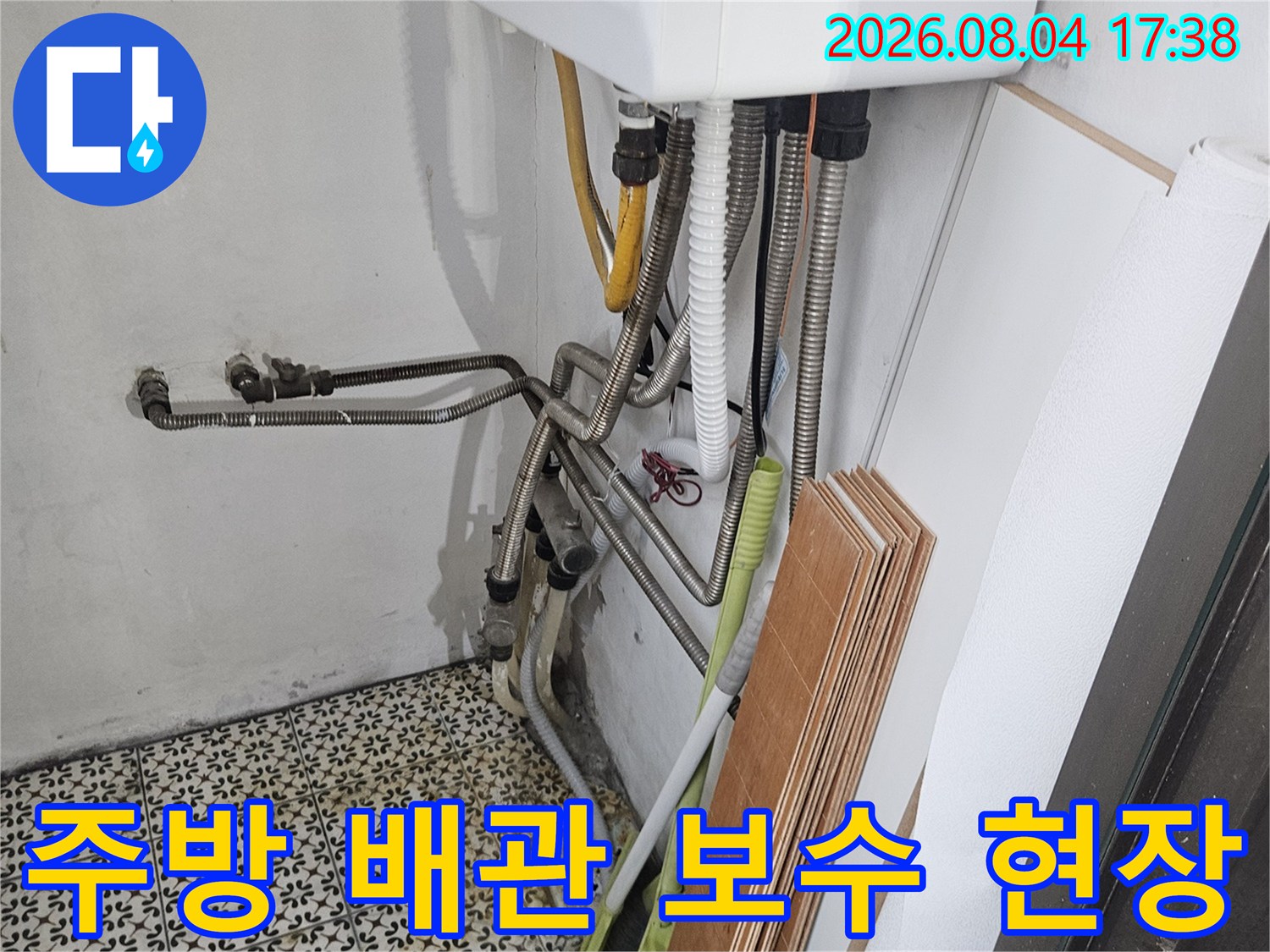 노란색 보온재로 감싸진 온수 배관과 금속 배관이 연결된 지점의 수리 모습