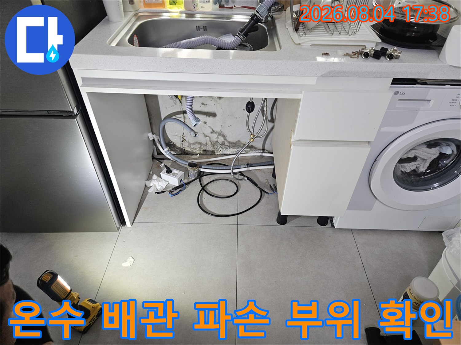 싱크대 밑 노출된 온수관 연결부의 누수 여부를 점검하는 모습