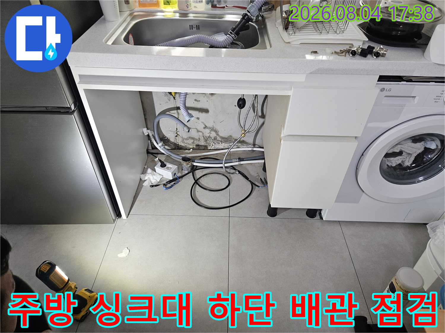 싱크대 아래 노출된 온수 및 급수 배관과 세탁기 연결부 확인