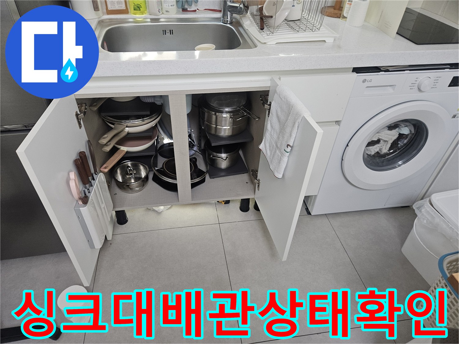 싱크대 아래 수납장 내부의 배관 및 연결 부위 상세 사진