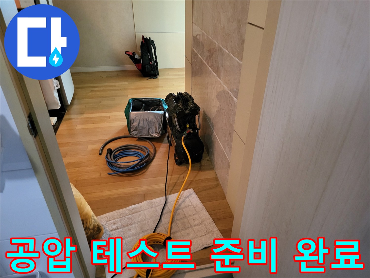 나무 바닥 위에 가지런히 놓인 누수 탐지용 호스와 장비 세트