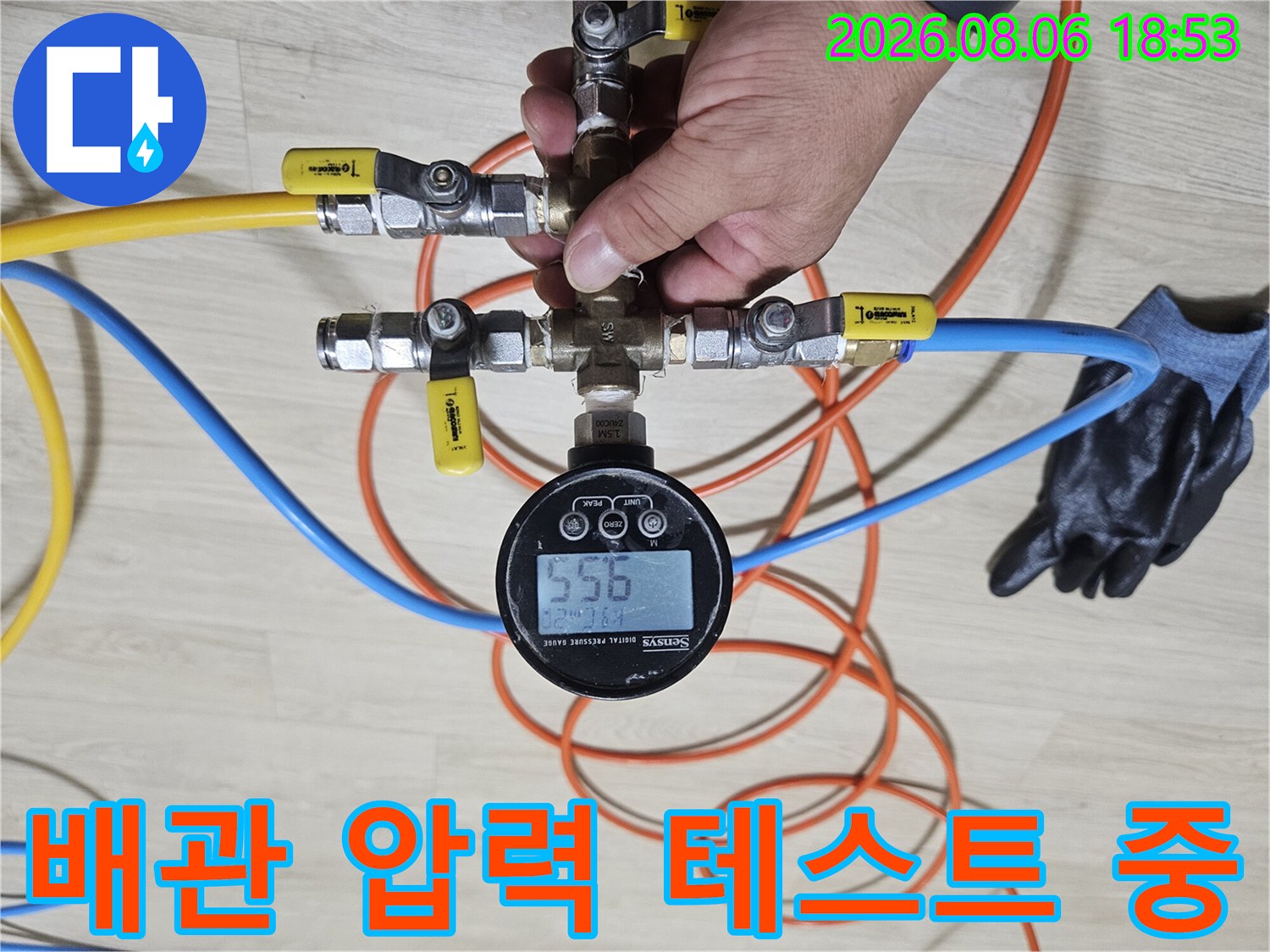 노란색과 파란색 호스가 연결된 배관 압력 측정 장비