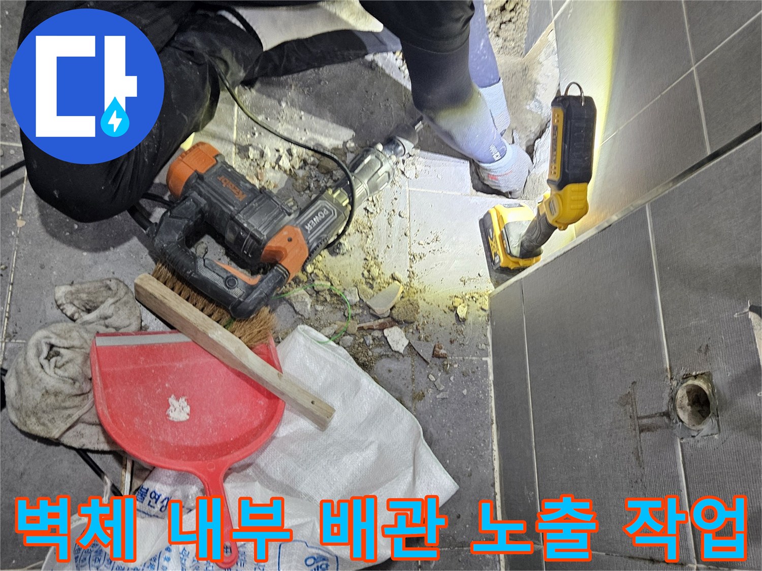 배관 손상 부위를 찾기 위해 진행 중인 타일 파쇄 현장 사진