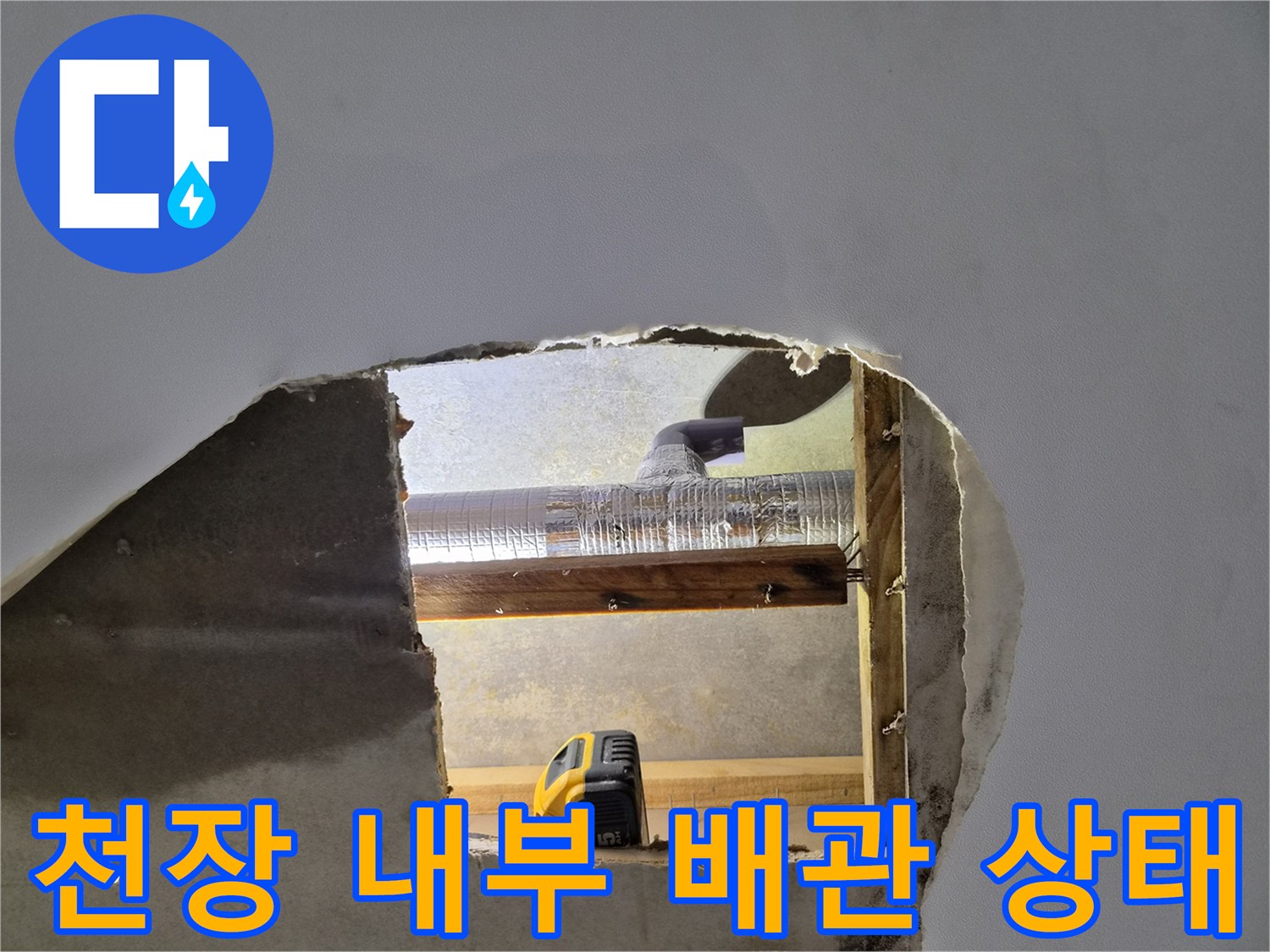 천장 마감재를 제거하여 노출된 에어컨 드레인 배관과 목재 구조물